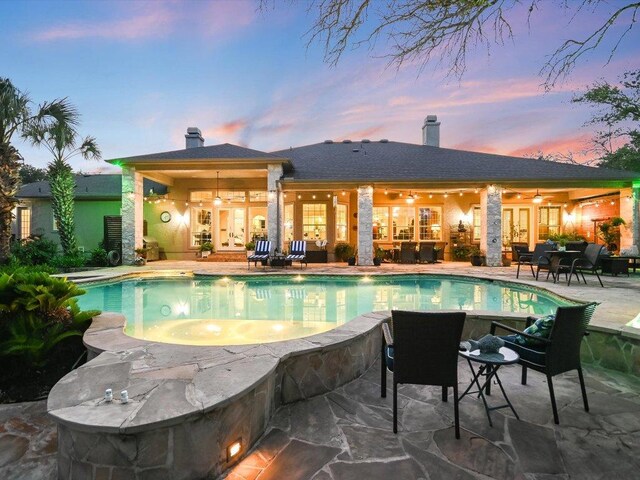 5709 Laguna Cliff Ln, Austin, TX 78734 - pool at dusk featuring a patio area, french doors, and an outdoor pool