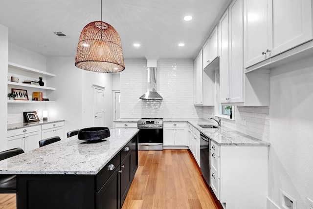 1200 Woodlawn St, Lockhart, TX 78644 - kitchen with stainless steel range with electric cooktop, wall chimney exhaust hood, open shelves, a sink, and dark cabinets