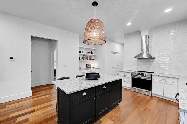 1200 Woodlawn St, Lockhart, TX 78644 - kitchen with stainless steel range with electric stovetop, wall chimney range hood, dark cabinetry, white cabinetry, and decorative backsplash