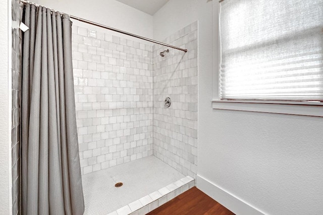 1200 Woodlawn St, Lockhart, TX 78644 - full bathroom with tiled shower, wood finished floors, and baseboards