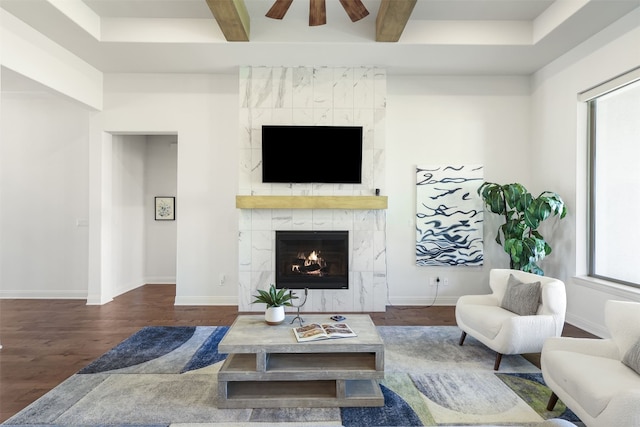 living area featuring baseboards, ceiling fan, wood finished floors, and a high end fireplace
