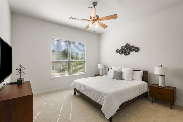 bedroom with a ceiling fan, baseboards, and light carpet