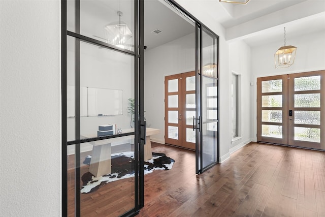 doorway with a chandelier, french doors, visible vents, and wood finished floors