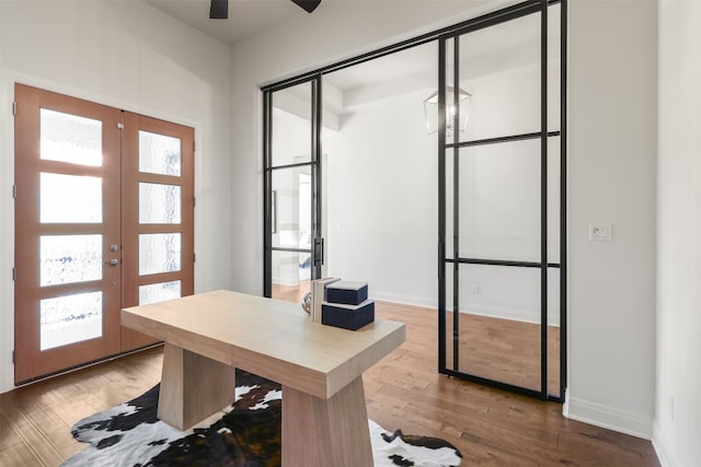 home office featuring baseboards, ceiling fan, french doors, and wood finished floors