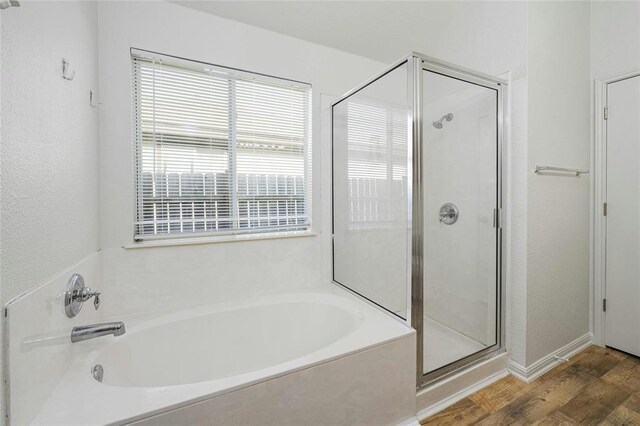 15205 Bullace St, Austin, TX 78724 - bathroom with a garden tub, a shower stall, wood finished floors, and baseboards