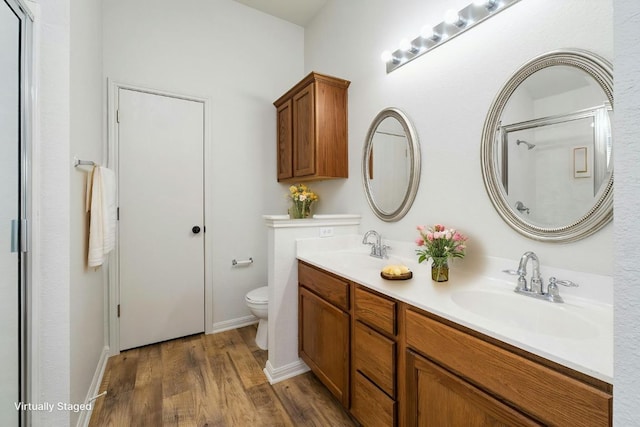 15205 Bullace St, Austin, TX 78724 - bathroom featuring double vanity, wood finished floors, toilet, a shower with door, and baseboards