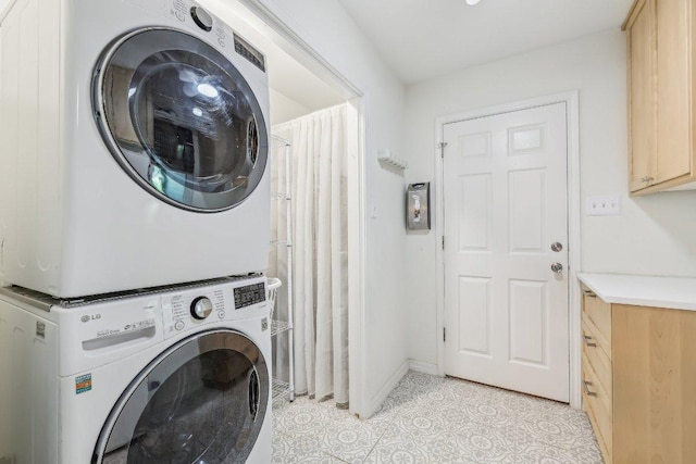 laundry area featuring light tile patterned floors and stacked washer and dryer