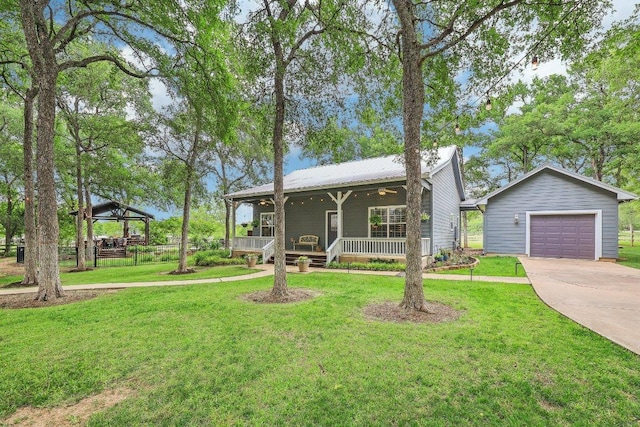 view of front facade featuring a gazebo, a detached garage, a front yard, concrete driveway, and covered porch