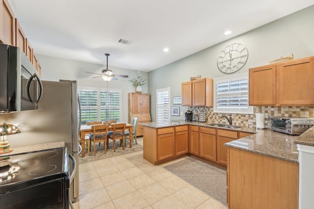 kitchen with black / electric stove, visible vents, a toaster, stainless steel microwave, and a peninsula