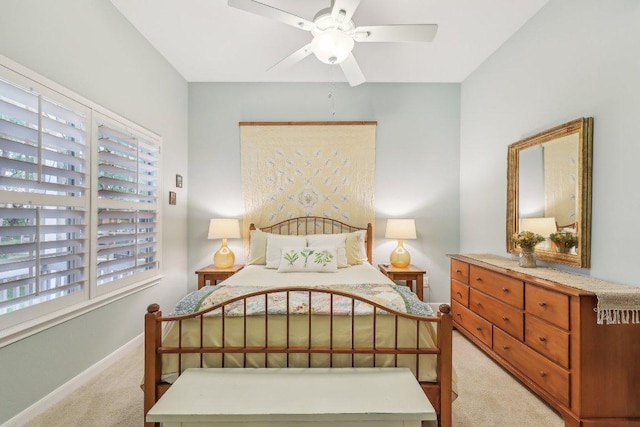 bedroom featuring light colored carpet, baseboards, and ceiling fan