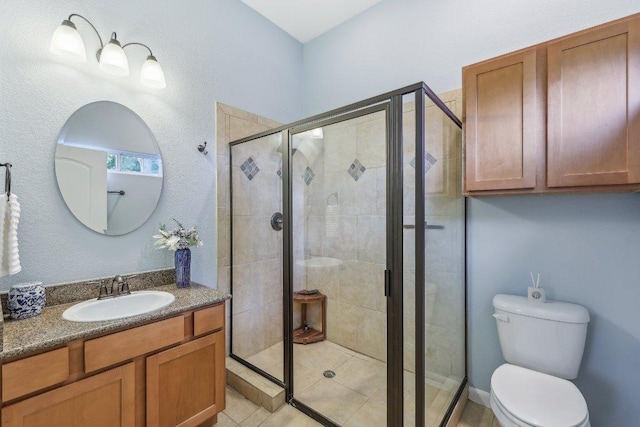 bathroom featuring vanity, a stall shower, and toilet