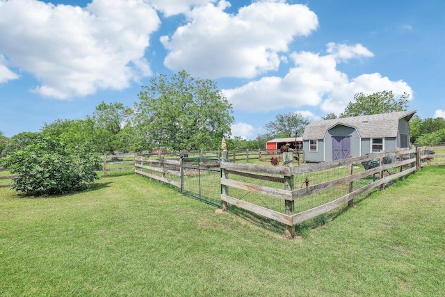 view of yard with fence, an exterior structure, a pole building, a rural view, and an outbuilding