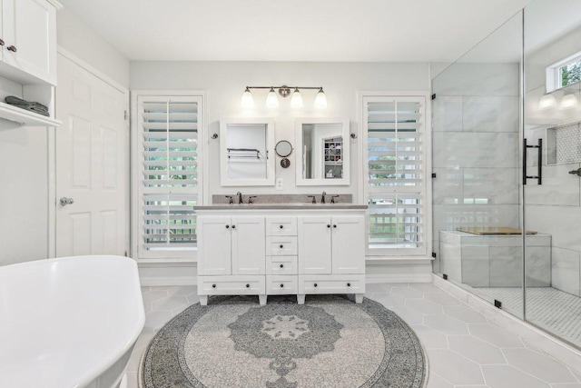 full bath with double vanity, a sink, a freestanding tub, and a shower stall
