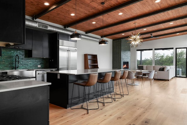 kitchen featuring visible vents, wooden ceiling, dark cabinets, backsplash, and stainless steel built in refrigerator