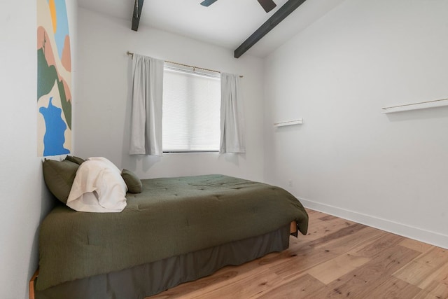 bedroom with baseboards, ceiling fan, wood finished floors, and beamed ceiling