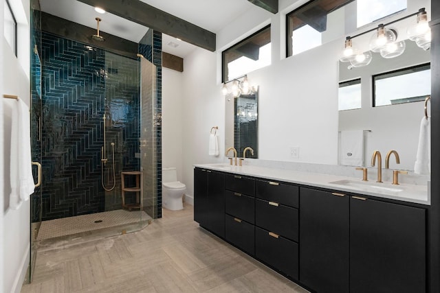 full bath featuring double vanity, toilet, a sink, and a stall shower