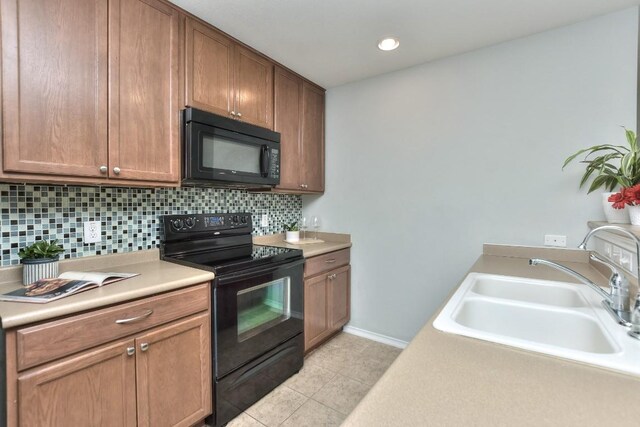 2206 Weiss Ln, Georgetown, TX 78626 - kitchen featuring black appliances, a sink, backsplash, light tile patterned floors, and light countertops