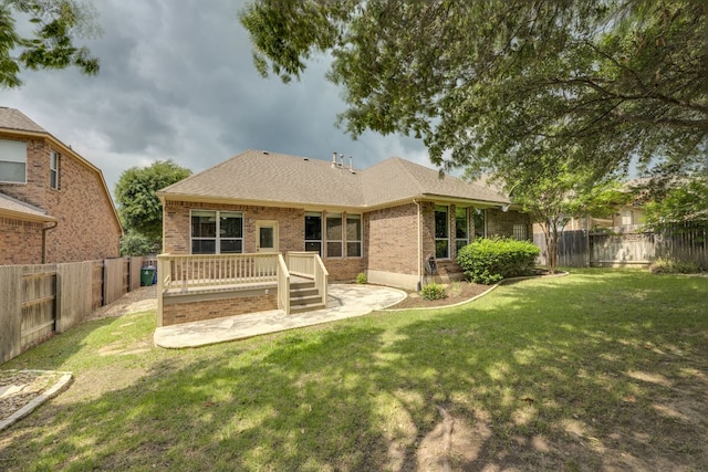 back of property with brick siding, a fenced backyard, a yard, and a patio