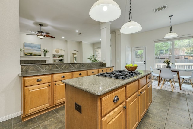 kitchen with ceiling fan, a kitchen island, decorative light fixtures, visible vents, and black gas cooktop