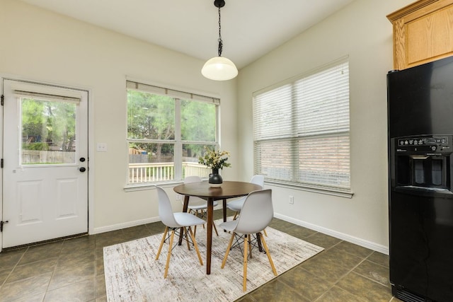 dining space with dark tile patterned floors and baseboards