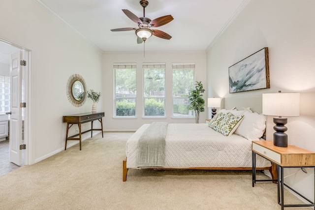 bedroom featuring crown molding, carpet flooring, a ceiling fan, baseboards, and ensuite bathroom