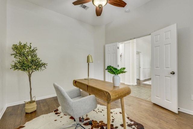 home office featuring a ceiling fan, baseboards, visible vents, and light wood-type flooring