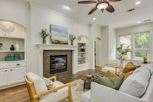 living area with arched walkways, dark wood-style flooring, and visible vents