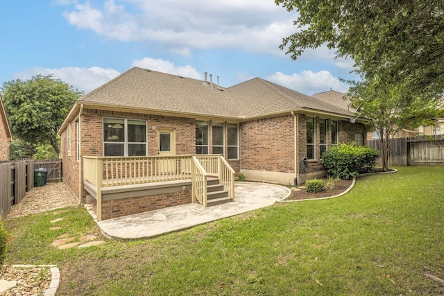 back of property with brick siding, a fenced backyard, and a yard