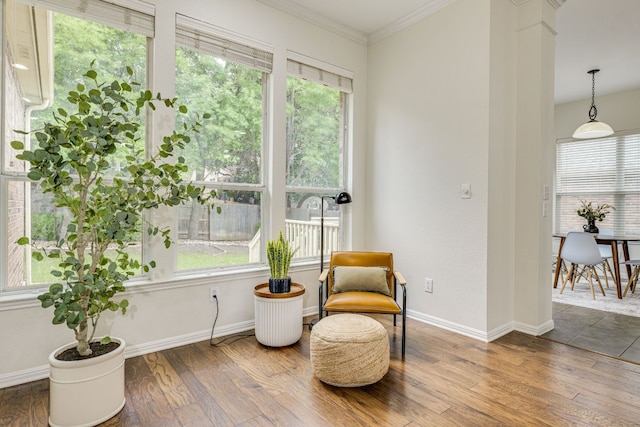 living area with crown molding, baseboards, and wood finished floors