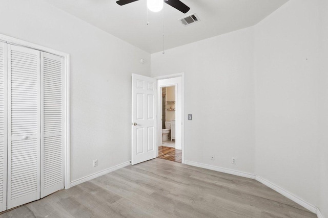 unfurnished bedroom featuring a closet, baseboards, visible vents, and light wood-style floors