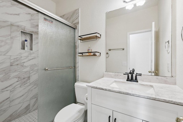 bathroom featuring vanity, toilet, and a stall shower