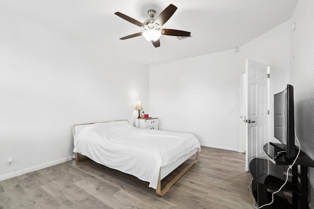 bedroom featuring baseboards, ceiling fan, and wood finished floors