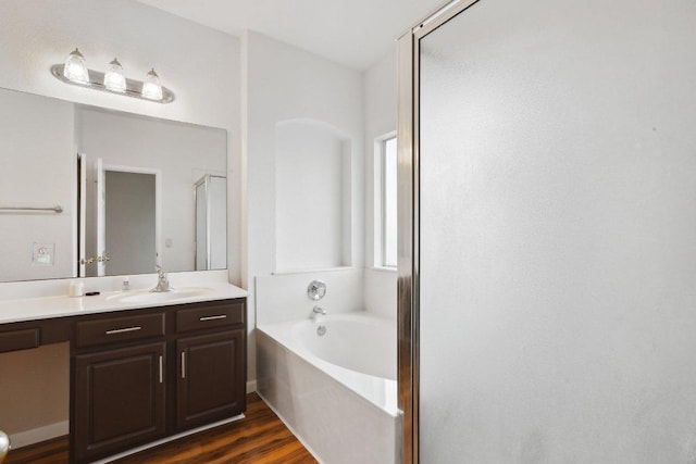 8117 Manx Dr, Round Rock, TX 78681 - bathroom featuring a garden tub, vanity, a stall shower, and wood finished floors