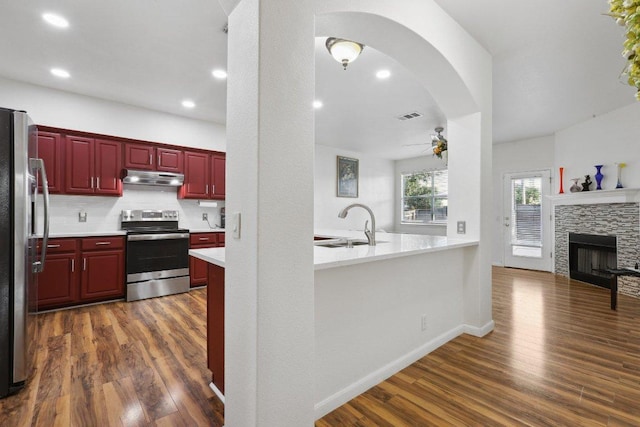8117 Manx Dr, Round Rock, TX 78681 - kitchen featuring appliances with stainless steel finishes, dark brown cabinets, under cabinet range hood, ceiling fan, and dark wood-type flooring