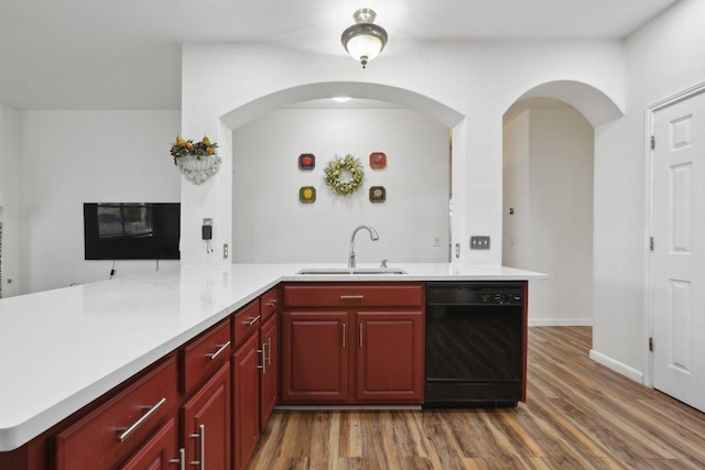 8117 Manx Dr, Round Rock, TX 78681 - kitchen featuring black dishwasher, wood finished floors, light countertops, and reddish brown cabinets