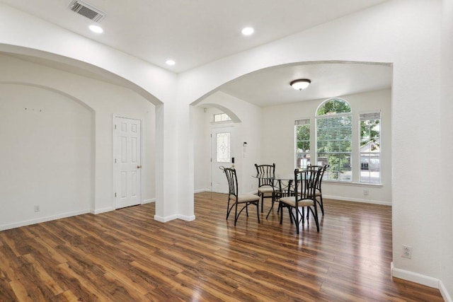 dining space with visible vents, arched walkways, wood finished floors, baseboards, and recessed lighting