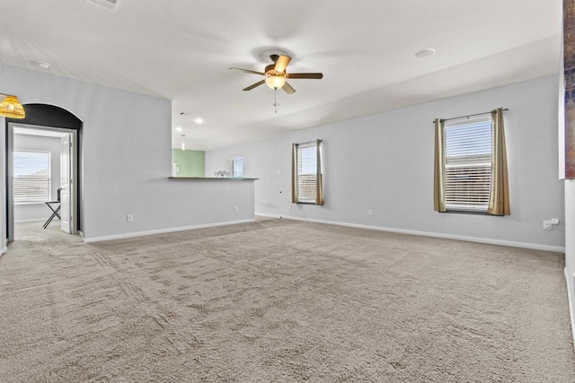 spare room with carpet floors, ceiling fan, and plenty of natural light