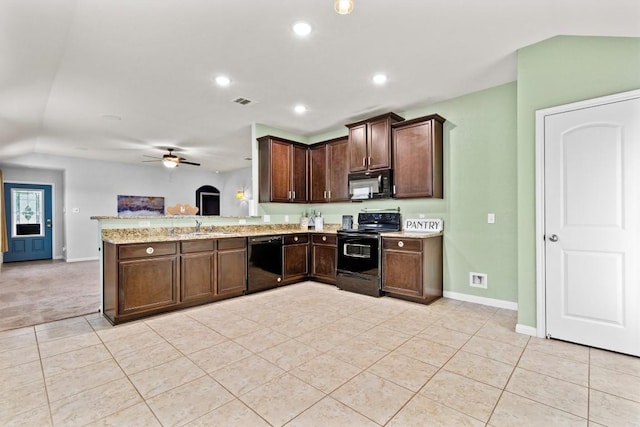 kitchen featuring light tile patterned flooring, open floor plan, baseboards, and black appliances