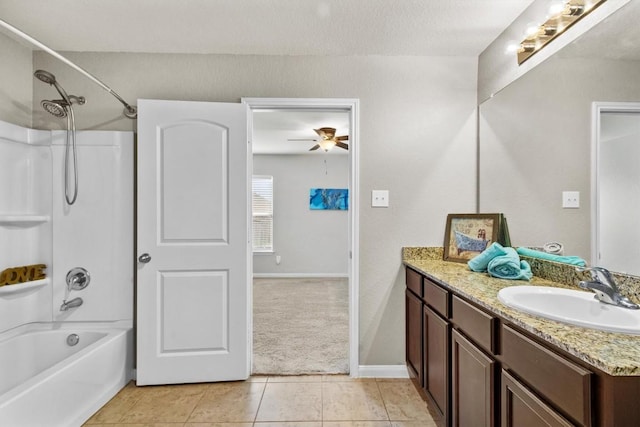 full bath featuring ceiling fan, baseboards, vanity, tile patterned floors, and washtub / shower combination