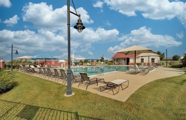 community pool with a lawn, a patio area, and fence
