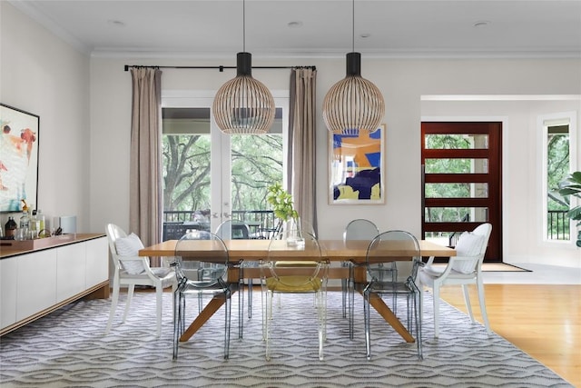 dining area with ornamental molding and wood finished floors