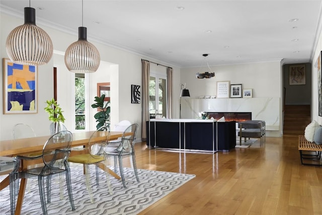 dining area with crown molding, wood finished floors, and a wealth of natural light