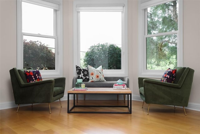 sitting room with baseboards and wood finished floors