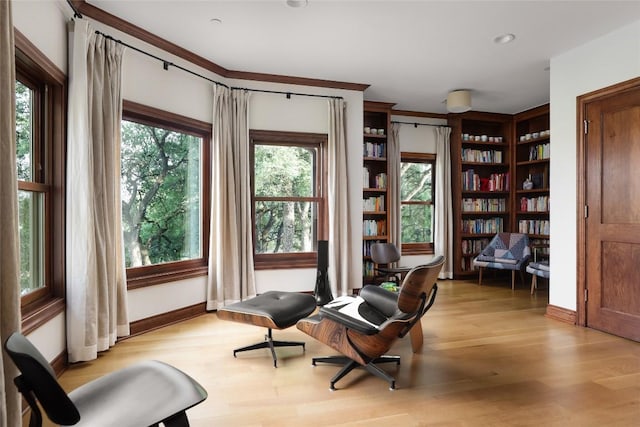 sitting room with baseboards and light wood-style flooring