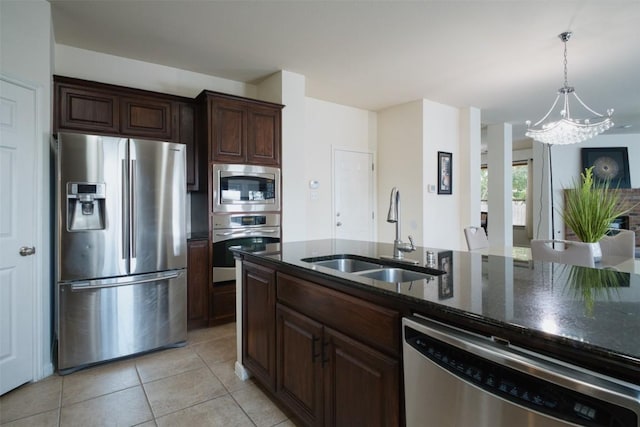 112 Bearing Cv, Austin, TX 78717 - kitchen with an inviting chandelier, a sink, dark stone counters, stainless steel appliances, and light tile patterned floors