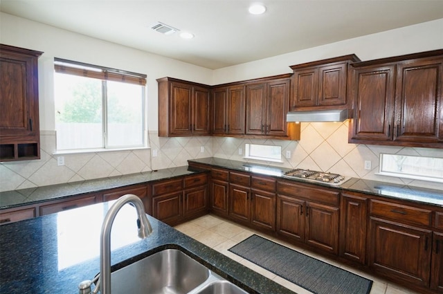 112 Bearing Cv, Austin, TX 78717 - kitchen featuring visible vents, dark stone counters, under cabinet range hood, a sink, and stainless steel gas stovetop