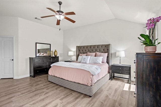 bedroom featuring a ceiling fan, visible vents, wood finished floors, baseboards, and lofted ceiling