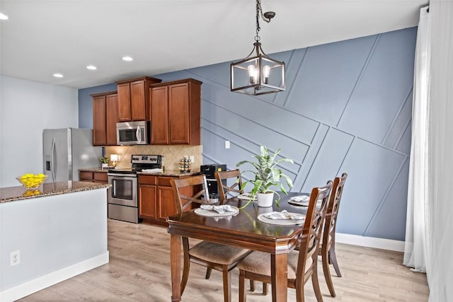 dining space featuring recessed lighting, a chandelier, and light wood finished floors