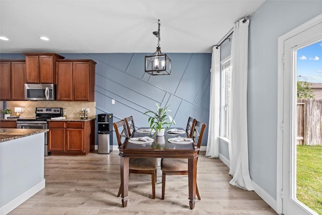 dining room with recessed lighting, baseboards, and light wood finished floors