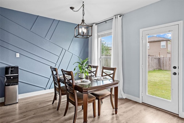 dining area with baseboards, wood finished floors, and a chandelier